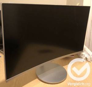 Ein Monitor steht auf einem Schreibtisch.