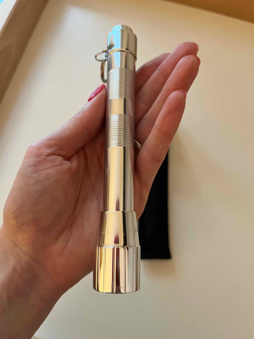 Eine Mini-Taschenlampe liegt getestet in einer Frauenhand.