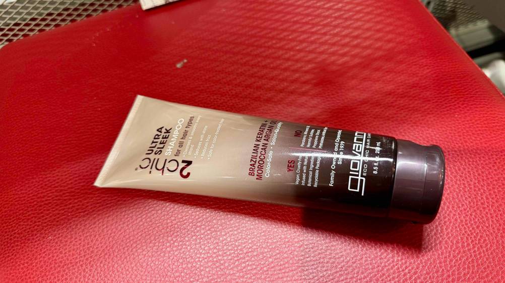 Auf einer roten Fläche liegt ein Moroccanoil-Shampoo im Test horizontal.