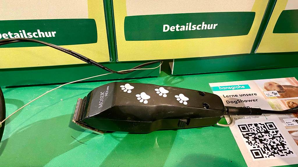 Neben einer getesteten Profi-Hundeschermaschine liegt ein Flyer mit QR-Code.
