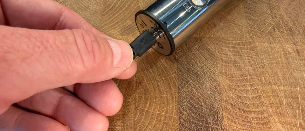 Eine Hand steckt das Ladekabel in den Mosuo Mos-Frother-001