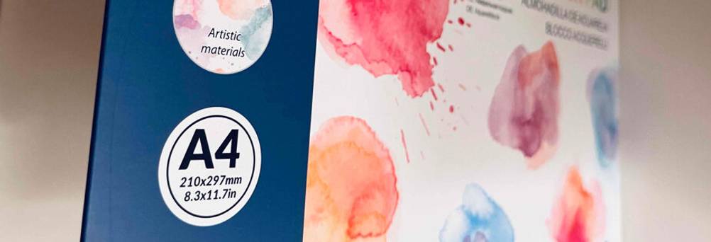 Ein DIN-A4-Block mit getestetem Aquarellpapier liegt auf einem weißen Regal.