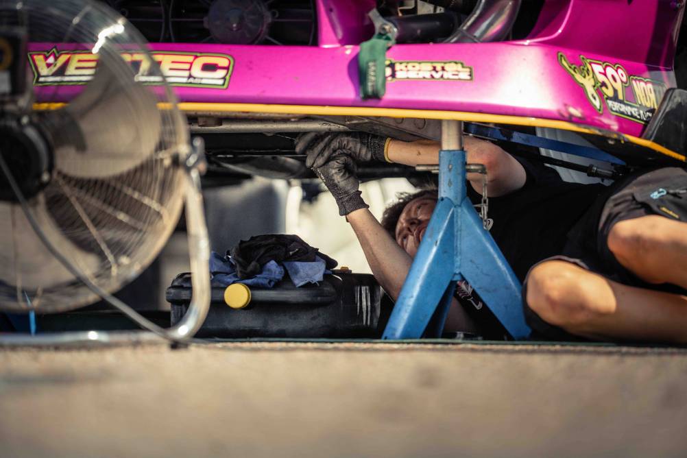 Motorbrücke im Test: Ein Mann liegt unter einem Auto und es ist eine Stütze erkennbar.