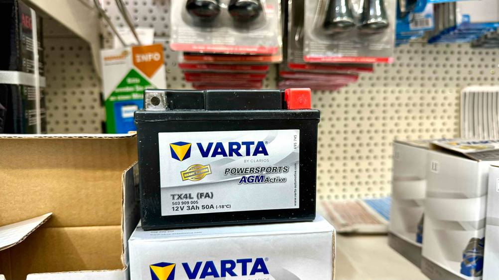 Eine getestete Motorrad-Batterie steht auf ihrer Verpackung in einem Verkaufsregal.
