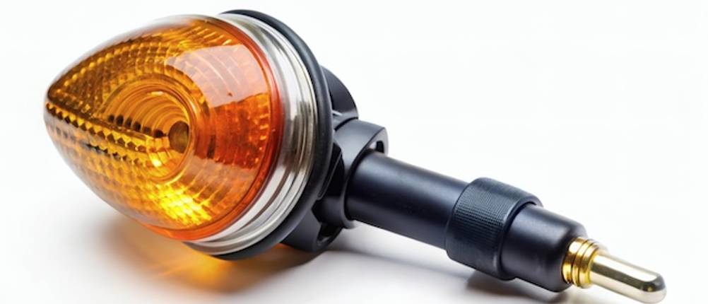 Vintage-Motorrad-Blinker vor einem weißen Hintergrund in Nahaufnahme im Test.