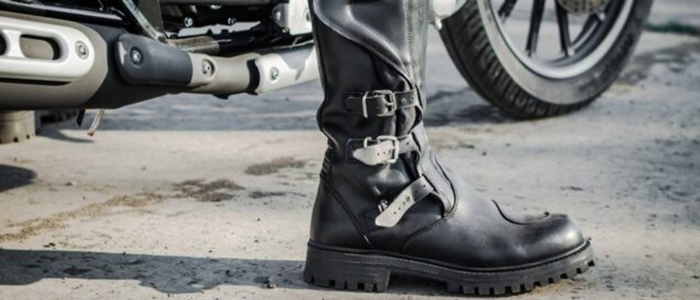 Motorrad-Stiefel in Nahaufnahme vor einem Motorrad.
