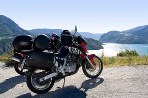 Motorrad-Navi getestet: Zwei Motorräder stehen am Rand der Straße, im Hintergrund ist eine bergige Landschaft und ein großer See.