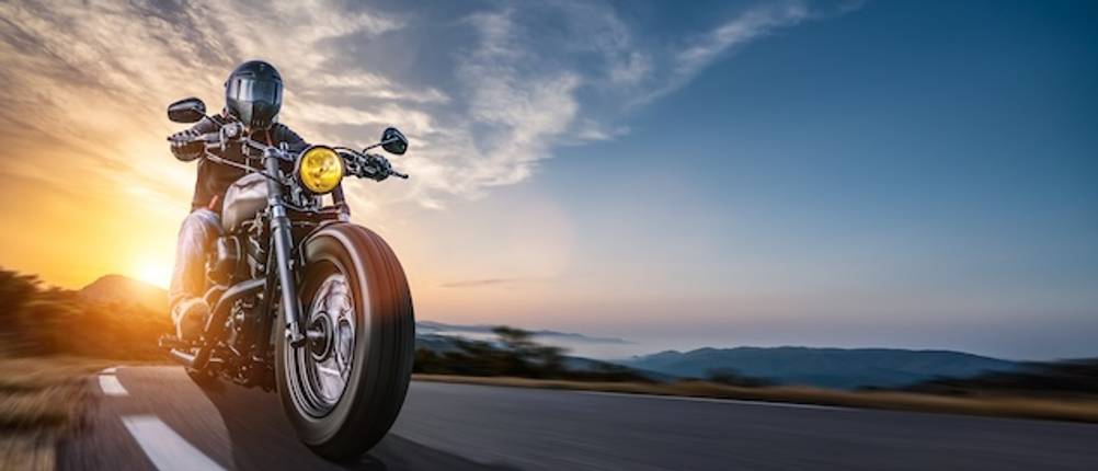 Motorrad-Unterwäsche für Herren im Langstrecken-Test: Auf einer Landstraße fährt ein Mann auf einem Motorrad an einer Küste entlang.