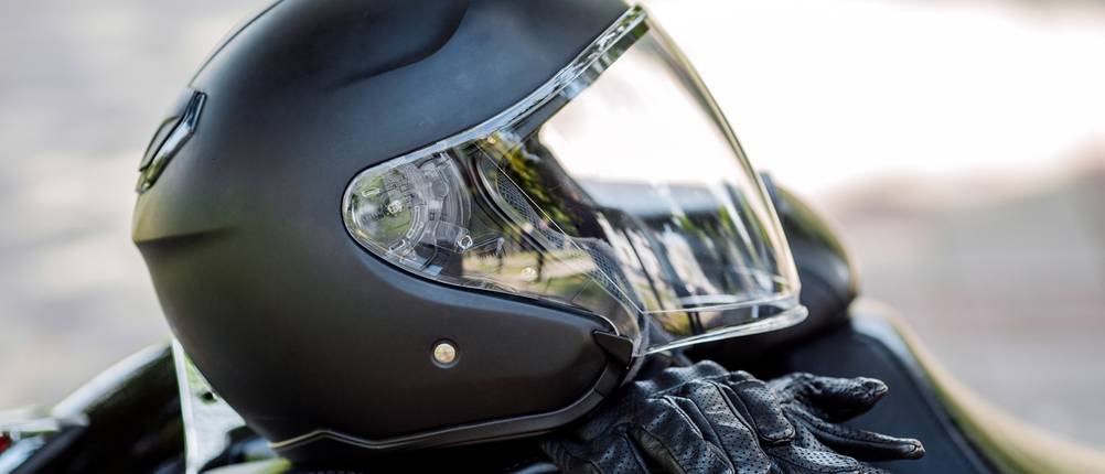 Motorradhelm liegt mit Handschuhen auf dem Sitz.