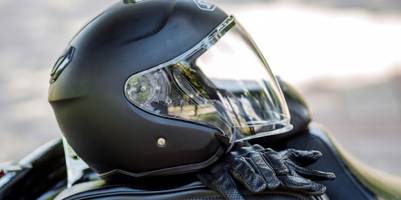 Motorradhelm liegt mit Handschuhen auf dem Sitz.