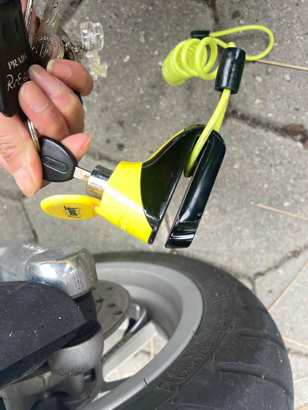 Getestet: Ein Motorradschloss von einer Hand mit dem Schlüssel gehalten.