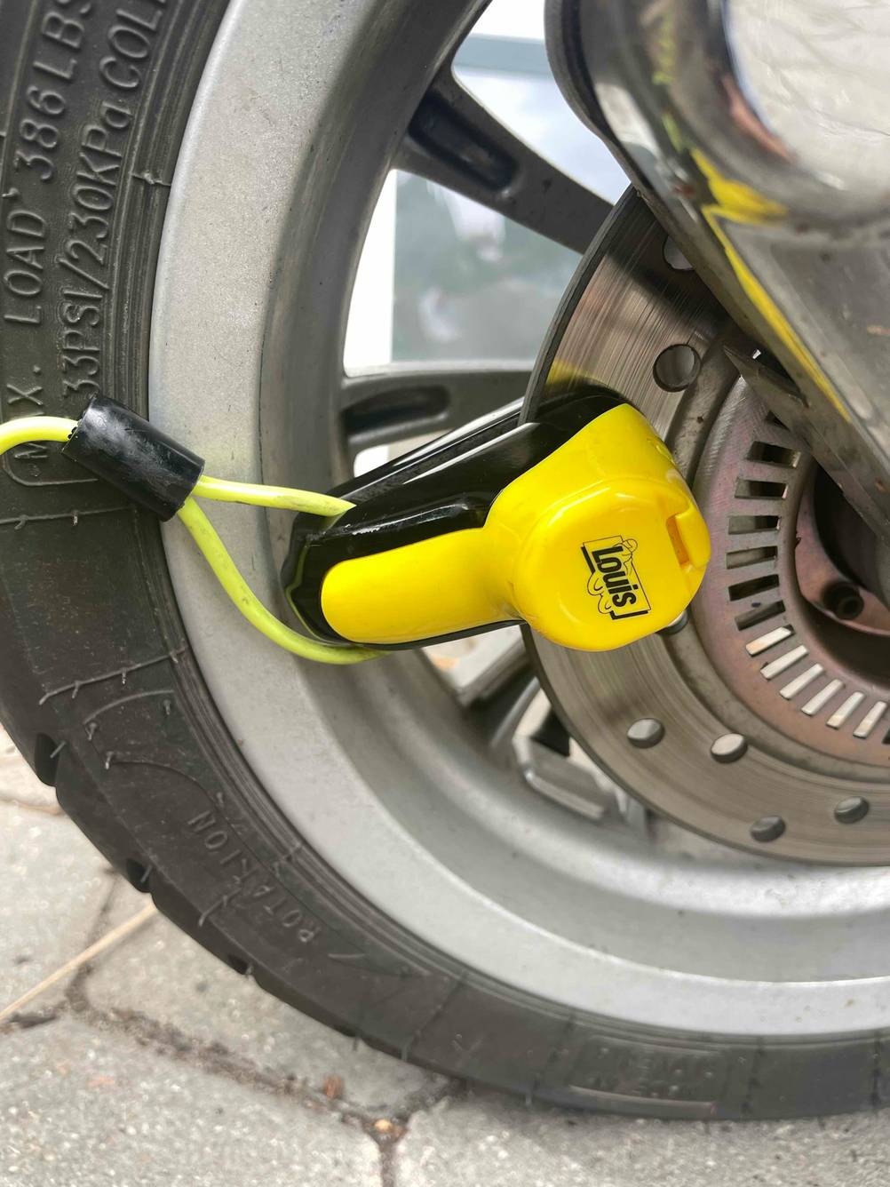 Motorradschloss im Test: Ein Schloss is an den Bremsbelegen eines Rollers befestigt.