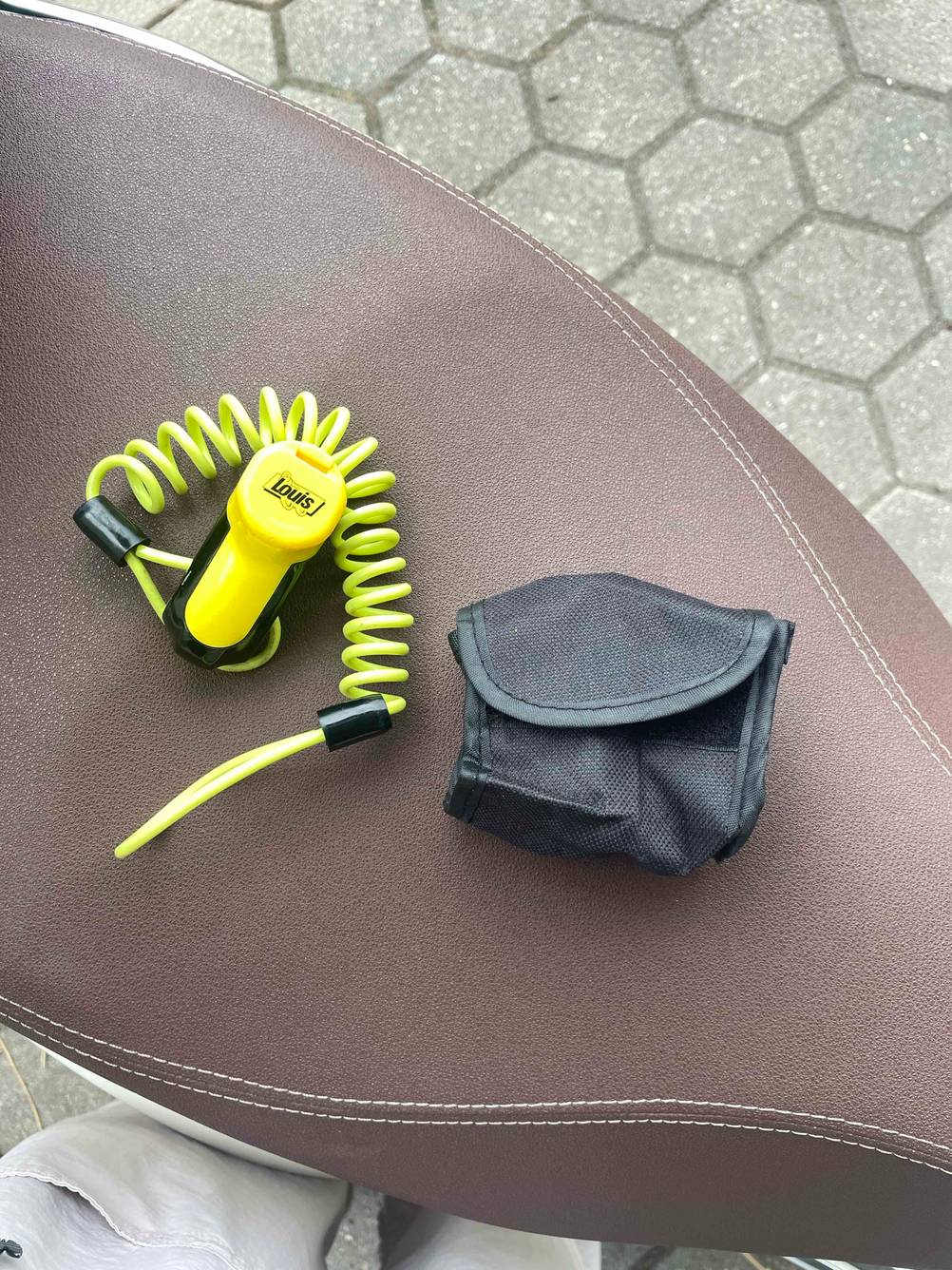 Motorradschloss getestet: Ein Schloss und seine Accessoire auf einem Motoradsattel.