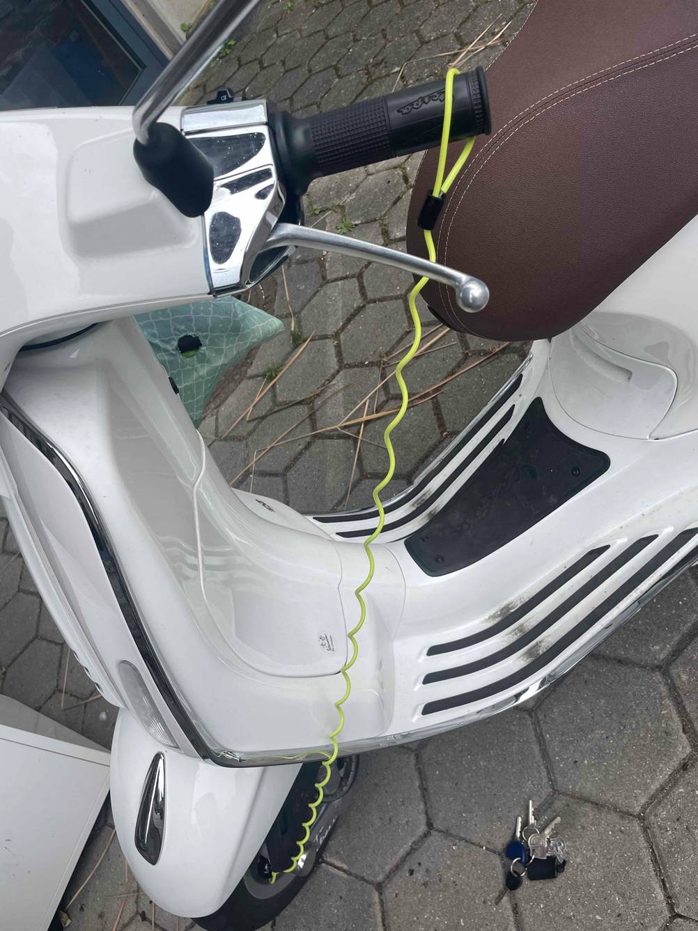 Ein getestetes Motorradschloss an einem Roller durch das Rad an den Lenker.