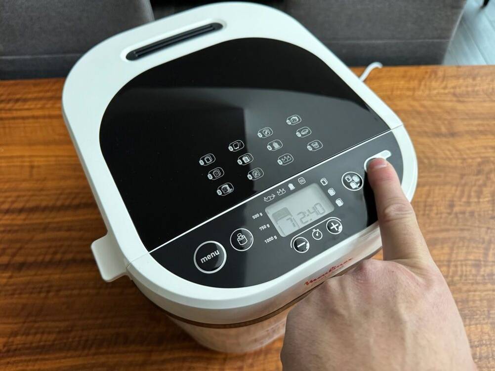 Eine Hand drückt einen Knopf auf dem Moulinex pain doré OW210130