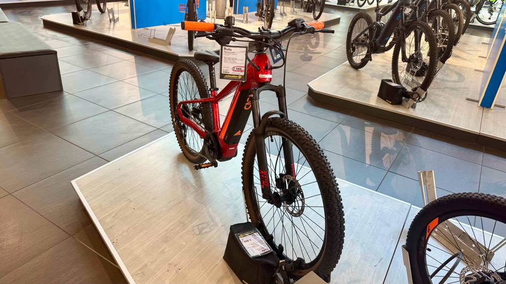 Das getestete Mountainbike 26 Zoll von schräg vorne auf einer Plattform in einem Ständer.
