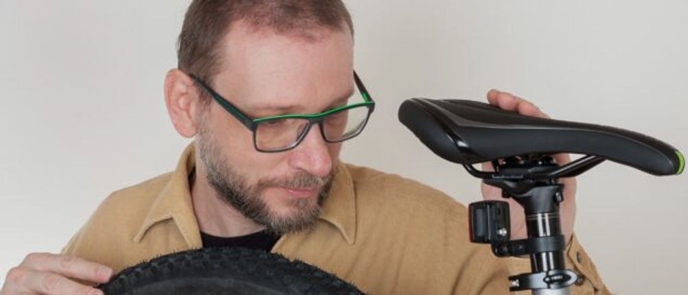 Ein Mann stellt die Sattelhöhe eines MTB-Sattels ein