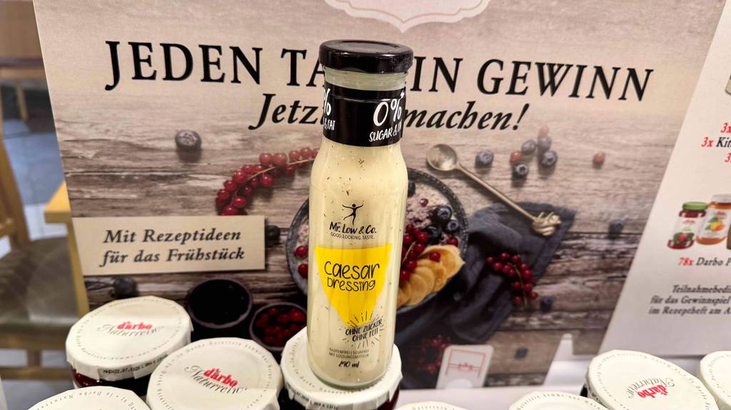 Getestetes Caesar-Dressing in einer 240-ml-Flasche steht auf Marmeladengläsern.