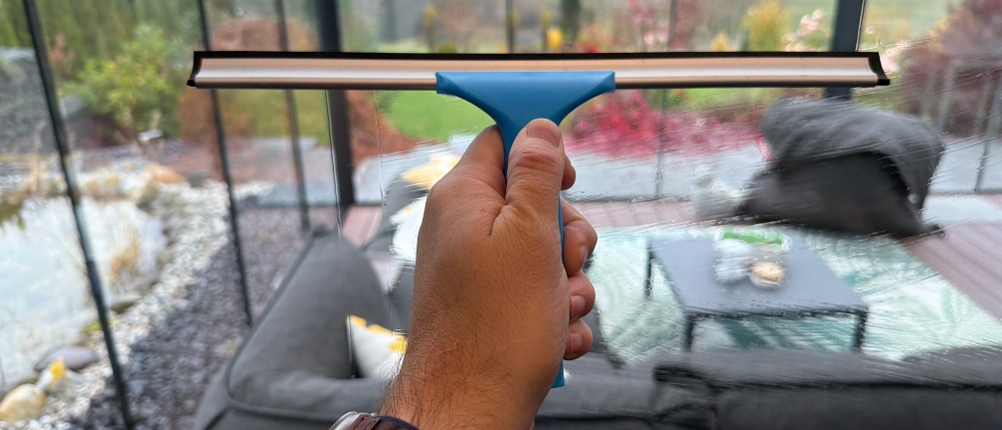 Eine Hand zieht ein Fenster mit dem Abzieher vom Mr. Siga SJ21578 ab