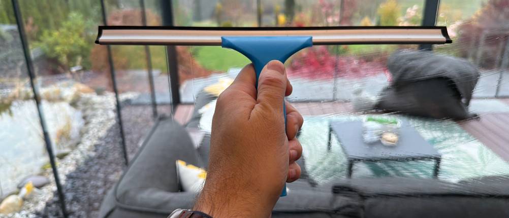 Eine Hand zieht ein Fenster mit dem Abzieher vom Mr. Siga SJ21578 ab