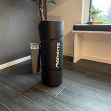 Die Msports-Gymnastikmatte Premium steht zusammengerollt auf einem Fliesenboden