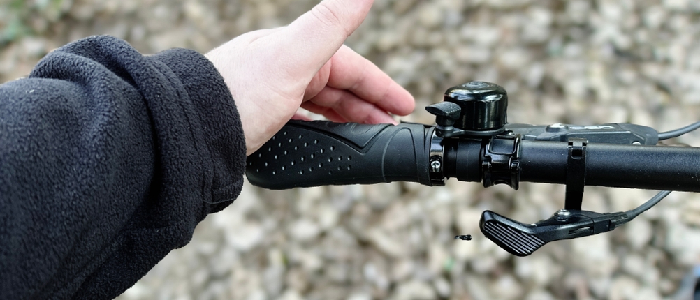 Eine Hand greift nach dem montierten Reetee-Fahrradgriff an einem Mountainbike-Lenker. Die geriffelte Oberfläche ist erkennbar.