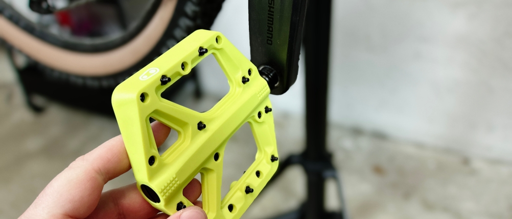 Ein Crankbrothers Stamp 1 Pedal wird von Hand an eine MTB-Kurbel montiert. Das Standard-9/16-Zoll-Gewinde sorgt für eine einfache Installation.