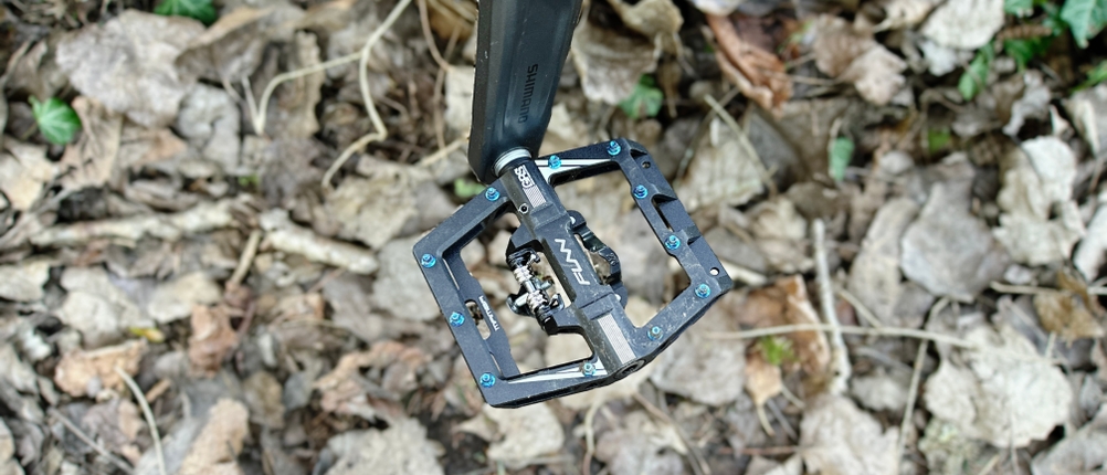 Eine Nahaufnahme im Freien zeigt das Funn Mamba Pedal und die offene Bauweise mit Pins und Klickmechanismus. Die robuste Aluminiumkonstruktion ist gut sichtbar.