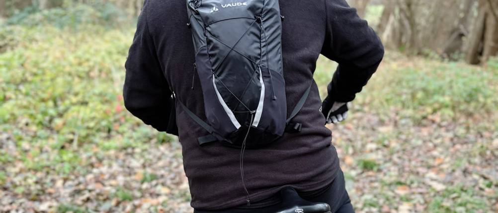 Ein Mann trägt den MTB-Rucksack von Vaude auf dem Rücken und fährt Fahrrad.