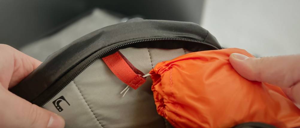 Die Schutzhülle wird beim Vaude MTB-Rucksack mit ihrem Beutel innen eingehakt.