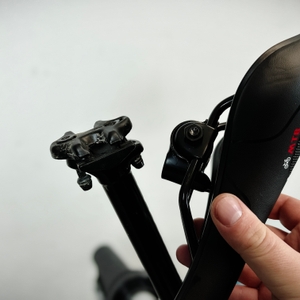 Der Youngdo MTB-Sattel wird neben eine Sattelstütze gehalten. Die spezielle Aufnahme ist sichtbar.