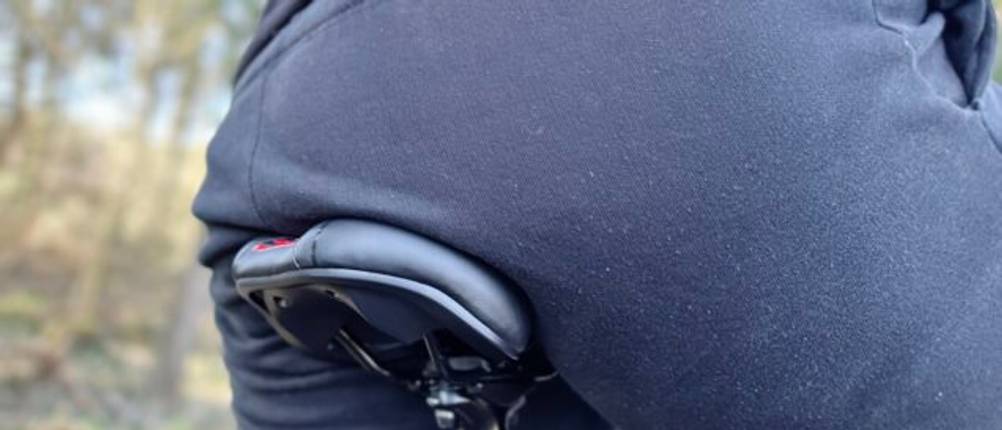 Ein Fahrradfahrer sitzt auf dem Youngdo MTB-Sattel während der Fahrt. Der Fokus liegt auf der Sitzfläche und der Passform des Sattels.
