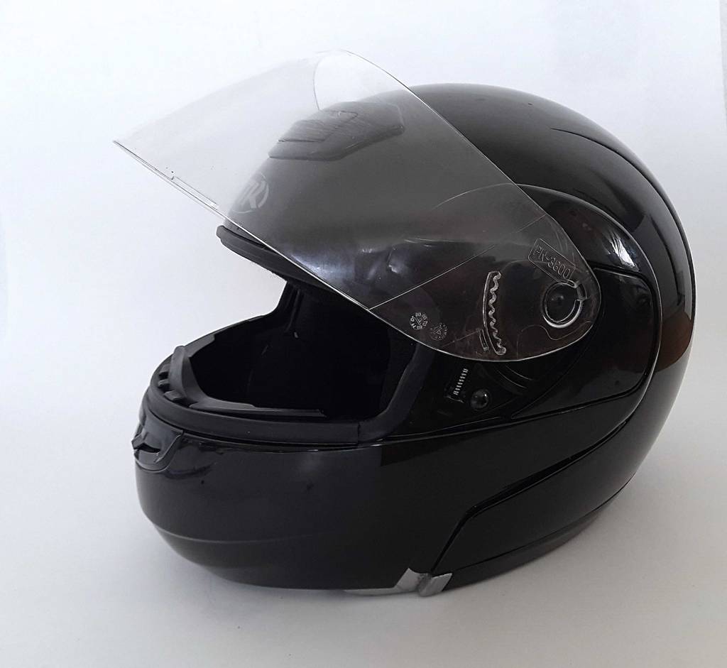 Im Test: Ein Motorradhelm steht mit offenem Visier auf einer weißen Fläche.