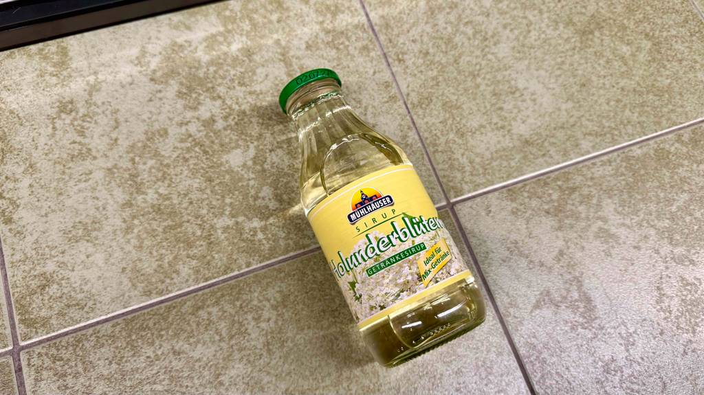 Eine Flasche getesteter Getränkesirup liegt auf einem Fliesenboden.