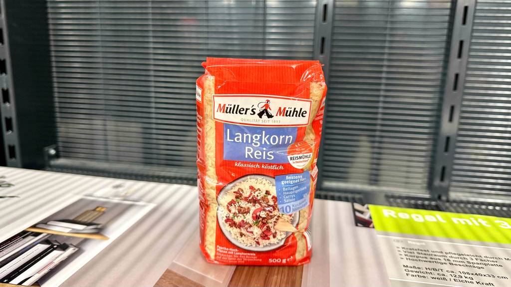 Eine Packung Langkornreis steht zum Testen auf einem Holzregal.