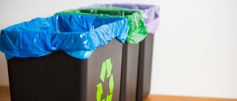 Mülltrennsysteme im Test: drei Mülleimer mit unterschiedlich farbigen Müllbeuteln.