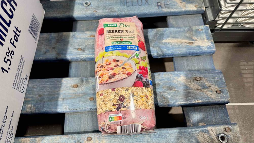 Auf einer Holzpalette liegt eine Packung des Müsli ohne Zuckerzusatz im Test.