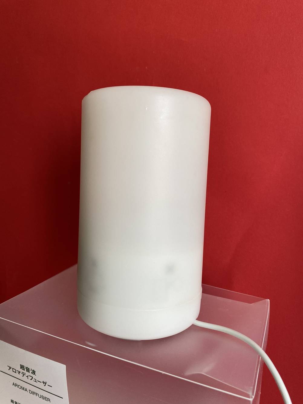 Ein getesteter Diffuser auf einer transparenten Box mit Stormkabel vor einer roten Wand.