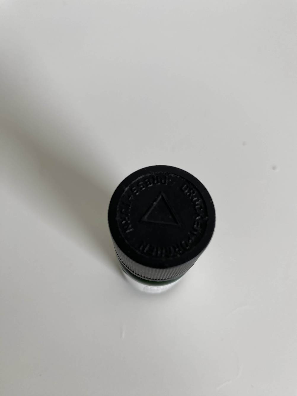 Im Test: Nahaufnahme des Deckels einer Flasche Aromatropfen von oben auf einer hellen Fläche.