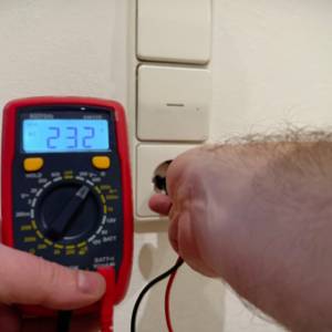 Das Multimeter von AstroAI wird an einer Steckdose verwendet und zeigt dabei die Zahl 232.