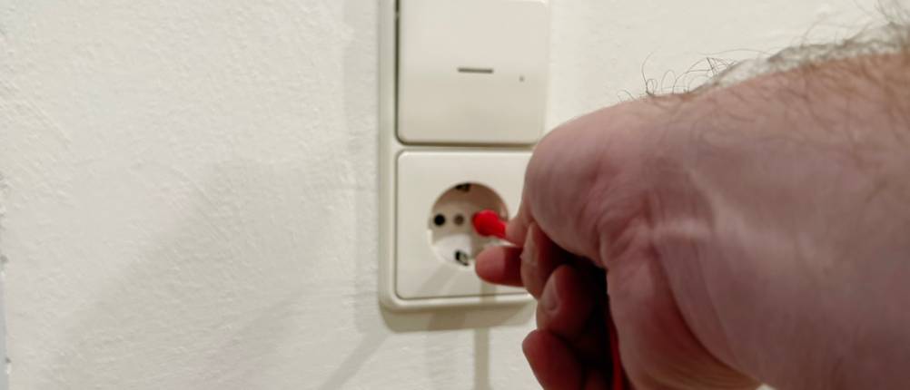 Die Spannungsmesser des Multimeters von AstroAI werden in die Steckdose gesteckt.