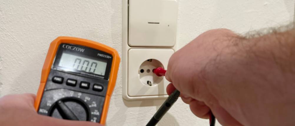 Die Spannungsmesser des Coczow Multimeters werden in eine Steckdose gesteckt.