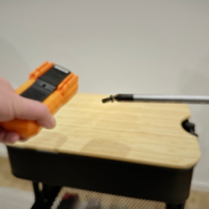 Die Schraube des Batteriefachs des Coczow-Multimeters haftet magnetisch an einem Schraubenzieher.