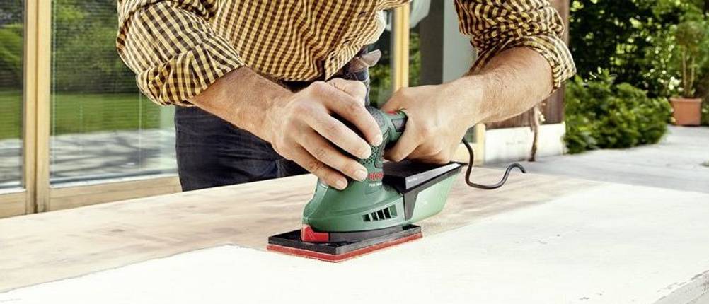 Bosch Multischleifer PSM 200 AES mit rechteckiger Schleifplatte bei der Arbeit.