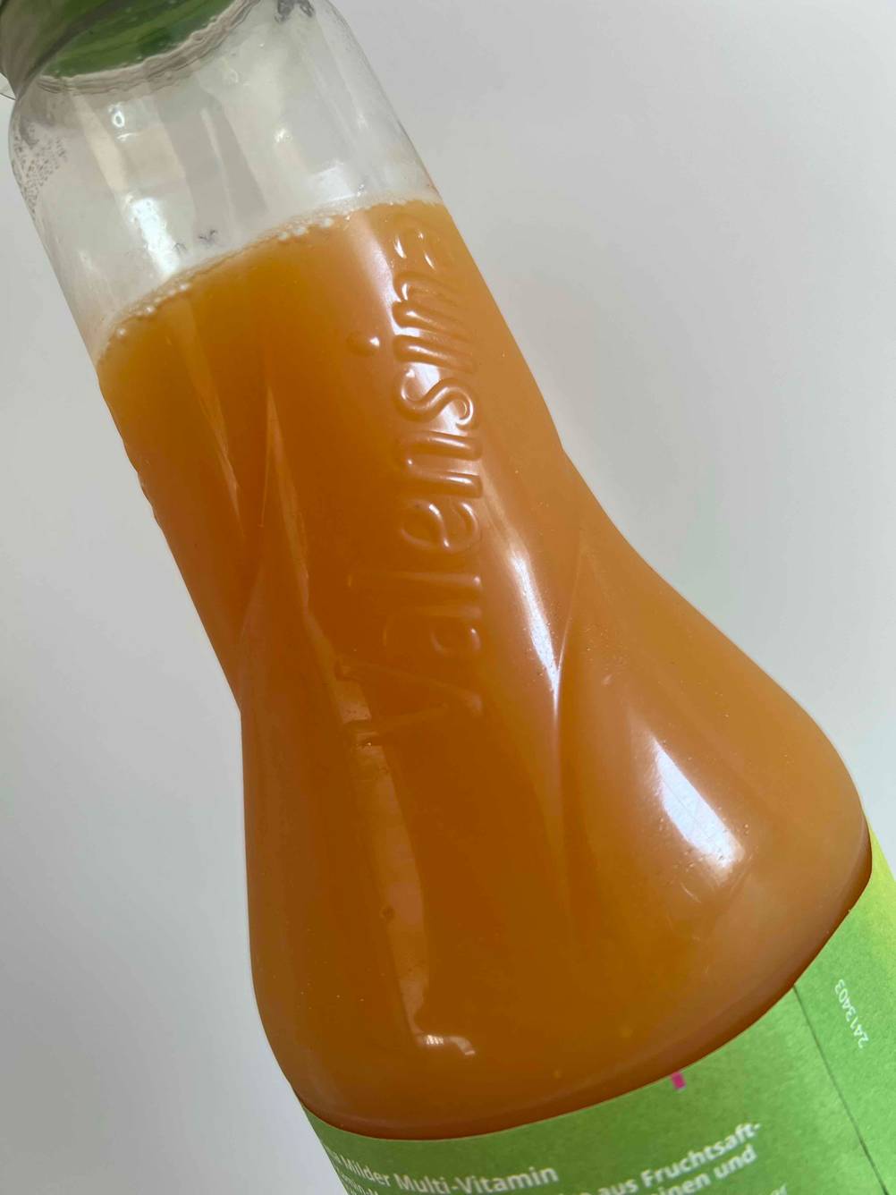 Multivitaminsaft im Test: Detailansicht des oberen Teils einer Flasche, auf der die Marke eingedruckt ist.