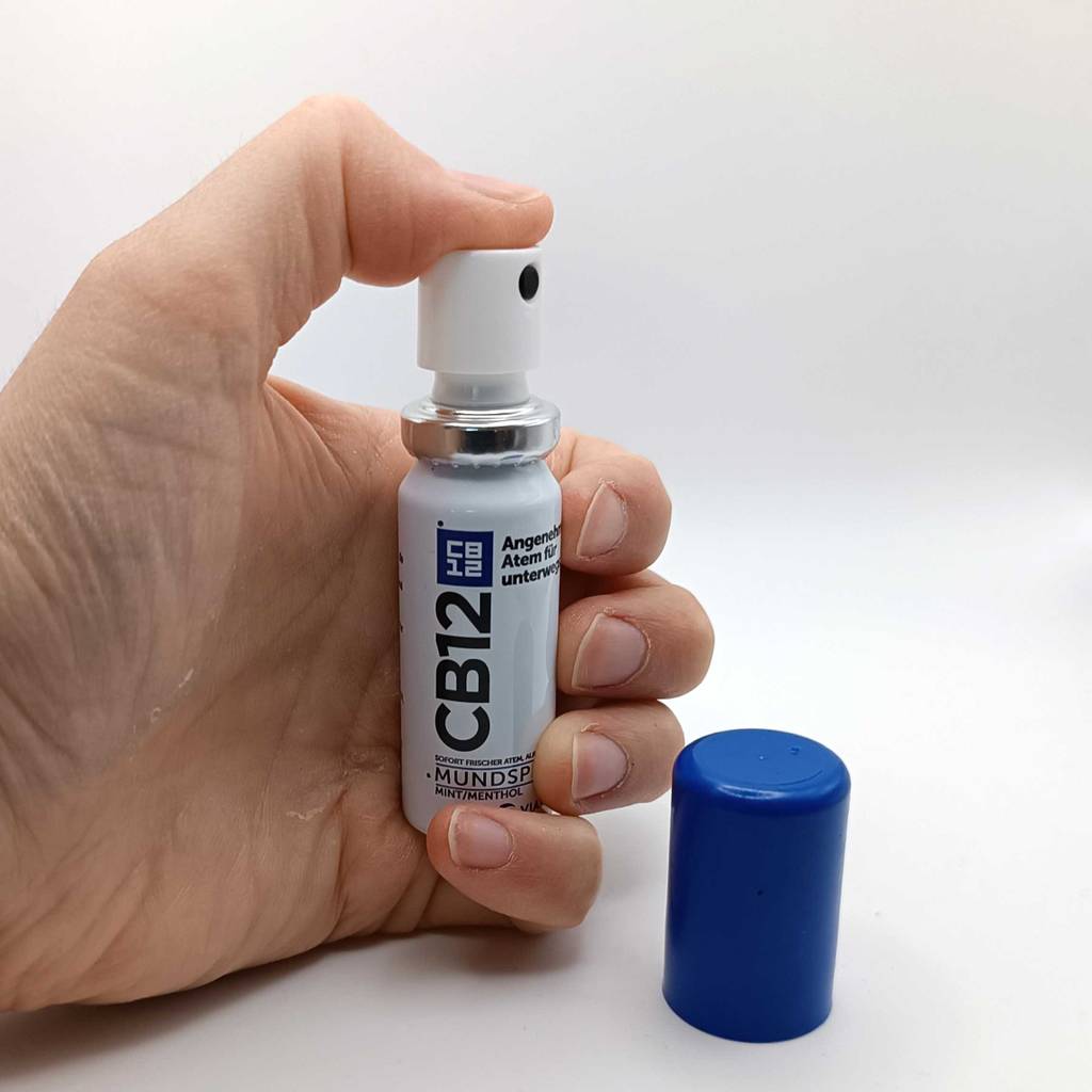 Im Test: Hand drückt auf den Sprühknopf eines Mundsprays.