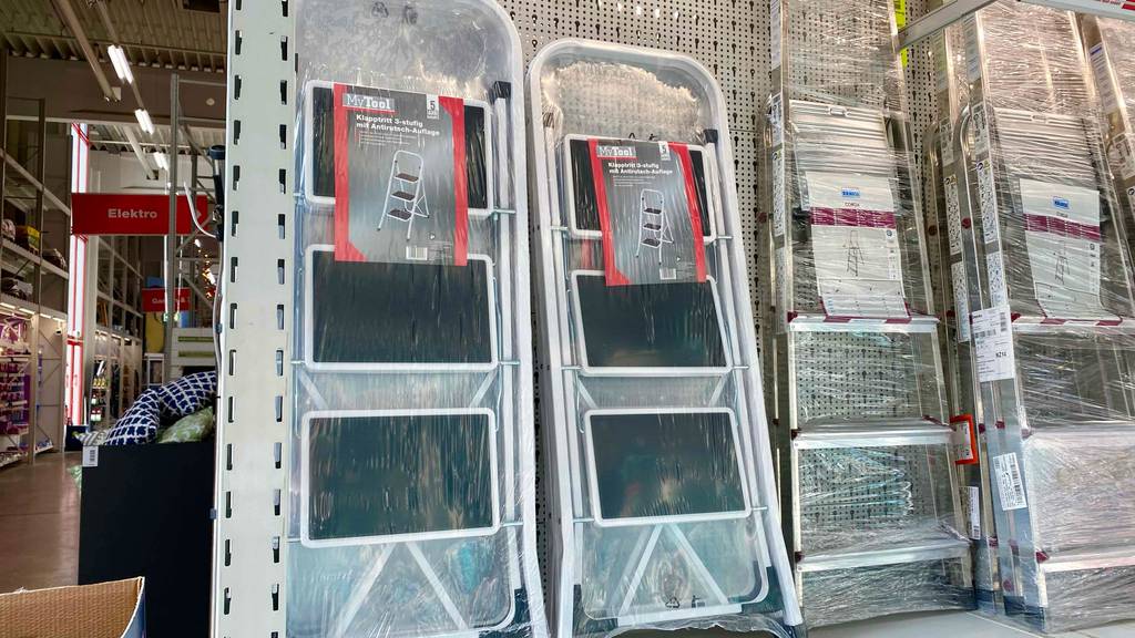 Im Test: Eine Trittleiter mit 3 Stufen steht zwischen weiteren Trittleitern in einem Baumarkt.