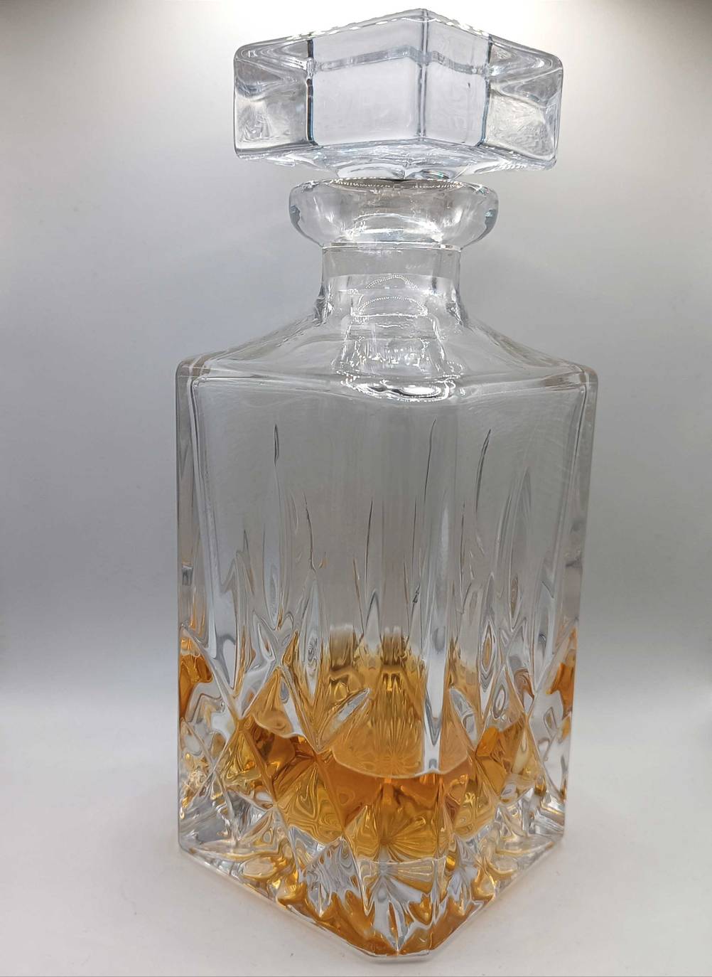 Im Test: Eine Whisky-Karaffe mit Whisky schräg vor einer hellen Wand.