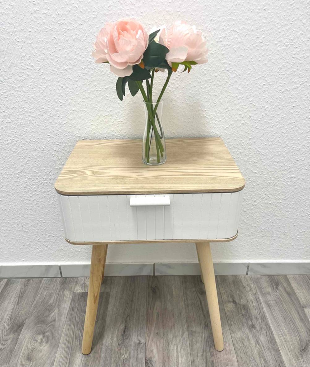 Auf einem Nachttisch im Test steht ein Strauß Rosen.