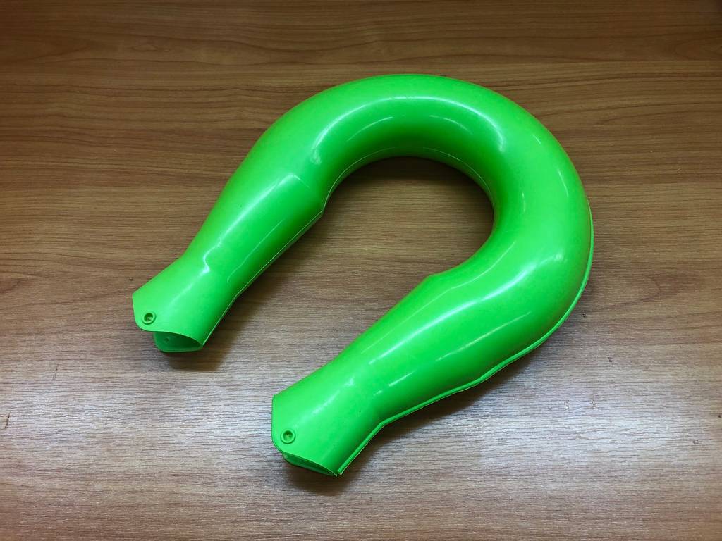Nackenwaermflasche-Test: Eine grüne Nackenwärmflasche liegt auf einer Holzfläche.